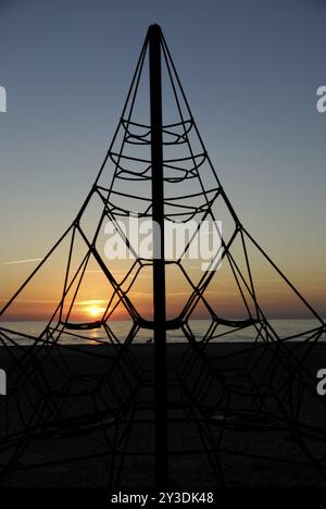 Cornice per arrampicata di fronte al tramonto sulla spiaggia di Ventspils, Lettonia, Europa Foto Stock