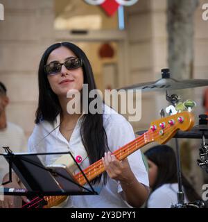 Gerusalemme, Israele - 18 luglio 2024: Una giovane donna che suona il basso come parte di un gruppo di musicisti di strada nel centro di Gerusalemme. Foto Stock