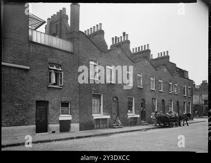 Turner Street, Stepney, Tower Hamlets, Greater London Authority, 1949. Numeri 56-64 Turner Street vista dall'incrocio di Newark Street con l'ingresso al 26 Newark Street in primo piano e un carro trainato da cavalli in piedi lungo la strada. Solo le case al 26 di Newark Street e al 64 di Turner Street sopravvivono ancora. Foto Stock