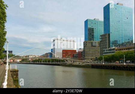 Le torri gemelle del complesso della porta di Isozaki e il ponte pedonale Zubizuri ad arco legato sul fiume Nerbiol Bilbao Paesi Baschi Euskadi Spagna Foto Stock