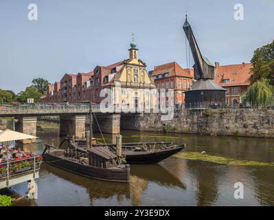 11 agosto 2024, bassa Sassonia, Lüneburg: Vista dallo Stintmarkt attraverso l'Ilmenau fino alla vecchia gru nel porto di Lüneburg. Foto: Markus Scholz/dpa Foto Stock