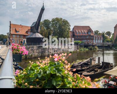 11 agosto 2024, bassa Sassonia, Lüneburg: Vista dallo Stintmarkt attraverso l'Ilmenau fino alla vecchia gru nel porto di Lüneburg. Foto: Markus Scholz/dpa Foto Stock