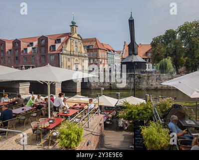11 agosto 2024, bassa Sassonia, Lüneburg: Vista dallo Stintmarkt attraverso l'Ilmenau fino alla vecchia gru nel porto di Lüneburg. Foto: Markus Scholz/dpa Foto Stock