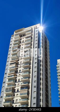 costruzione di un alto edificio grigio, finestre, edificio per uffici, oggetti cittadini, cielo blu. Foto di alta qualità Foto Stock