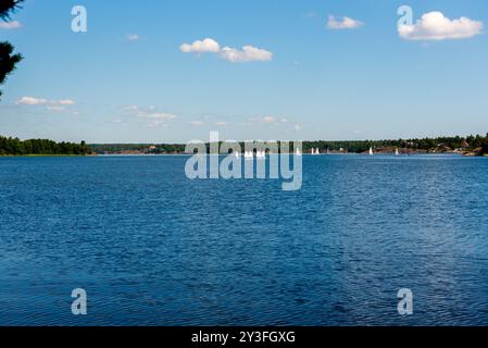 Barche a vela sull'acqua in Svezia. Bambini che navigano su un lago con piccole barche a vela (catamarani). Foto Stock