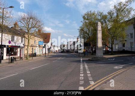 Giornata tranquilla e soleggiata sulla strada principale di Great Dunmow, Essex, Regno Unito, con un monumento commemorativo alla prima e alla seconda guerra mondiale a un incrocio stradale e alle aziende locali. Foto Stock