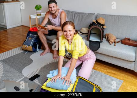 Una giovane coppia che prepara le valigie da viaggio, preparandosi per una vacanza. Foto Stock