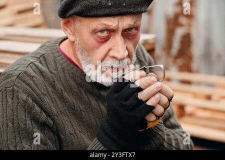 Un senzatetto maturo con un bicchiere per strada, primo piano Foto Stock