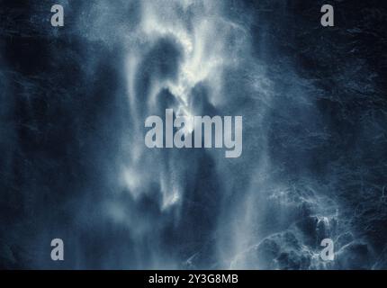 Parte di una magnifica grande cascata come un'immagine da sogno, quasi astratta ad alto contrasto. Acqua bianca su scogliere buie. Foto Stock