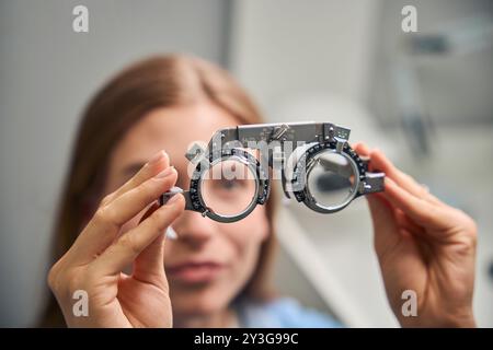 Paziente di sesso femminile che regge il casco di prova per il test della vista Foto Stock