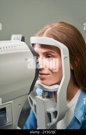 Paziente sottoposto a una procedura di esame oculare automatizzato Foto Stock