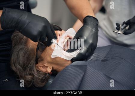 Il paziente è seduto sulla sedia dentistica Foto Stock