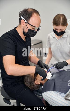 Assistente aiuta il dentista con il lavoro Foto Stock