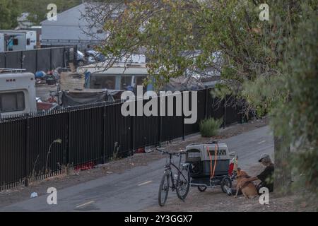 Sacramento, CA. 26 agosto 2024. Il residente di Camp Resolution Steven Goble siede con il cane e uno dei due gatti che sbirciano fuori da una cassa di Shonn Adams fuori dall'accampamento dei senzatetto lunedì 26 agosto 2024, prima che la città venisse a rimuoverlo. Adams, che dipende da un generatore per il suo ossigeno, era stata salvata dal campo dalla Sacramento Homeless Union. Goble ha detto che non era sicuro di dove stesse andando, ma era felice di salvare i suoi animali. (Credit Image: © Renée C. Byer/ZUMA Press Wire) SOLO PER USO EDITORIALE! Non per USO commerciale! Foto Stock