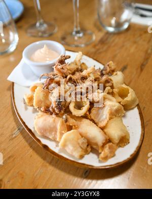 Una porzione di calamari fritti con salsa all'aglio in un ristorante europeo Foto Stock
