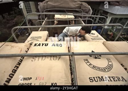 Lavoratori che caricano sacchi di tè su un camion presso la fabbrica di tè Kayu Aro nel villaggio di Kersik Tuo, Kayu Aro, Kerinci, Jambi, Indonesia. Foto Stock