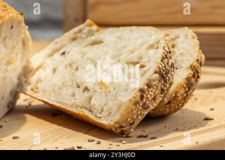 Pane fatto in casa e fette sul tavolo della cucina. Pane di segale con impasto naturale e vista ravvicinata dei semi Foto Stock