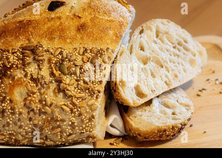 Pane fatto in casa e fette sul tavolo della cucina. Pane di segale con impasto naturale e vista ravvicinata dei semi Foto Stock