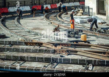 Team di lavoratori impegnati nella saldatura di ferrovie e nella riparazione di binari di tram. Riqualificazione urbana, potenziamento dei percorsi Foto Stock