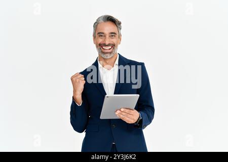 Uomo d'affari felice di mezza età con un tablet che celebra il successo, isolato. Foto Stock