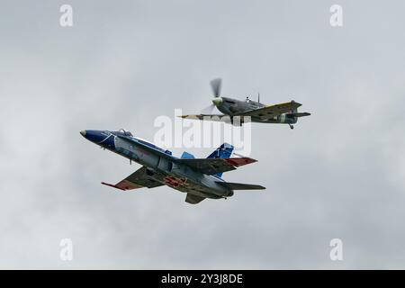 La Royal Canadian Air Force CF-188 Hornet 774 del 425 Tactical Fighter Squadron vola nella formazione con un Supermarine Spitfire World War Two Fighter Foto Stock