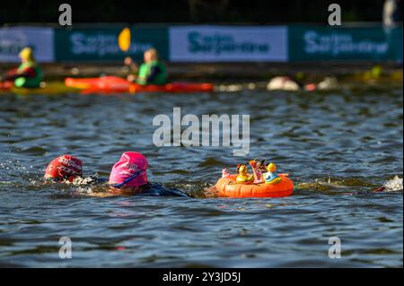 Swim Serpentine nell'Hyde Park di Londra è un evento annuale in cui circa 6.000 nuotatori, di età compresa tra i 10 e i 86 anni, si recano nelle acque fredde per nuotare in una varietà di distanze, tra 800 e 10 km circa. Nessuno è un vincitore, cercano di nuotare al meglio. L'acqua è di 17,5 gradi oggi, ma il sole splende ed è di 19 gradi quando escono dall'acqua. Foto Stock