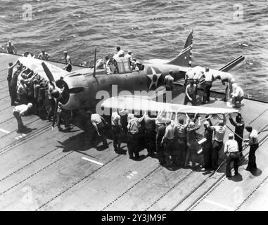 Il personale del ponte di volo della US Navy manovra un Douglas SBD-3 Dauntless di squadrone di bombardamento VB-6 su un supporto ruota sul bordo del ponte sulla portaerei USS Enterprise (CV-6), 17 aprile 1942 - foto della US Navy Foto Stock