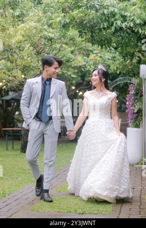 un paio di uomini e donne in pose eleganti in piedi in pose formali informali che camminano guardandosi intimamente e romanticamente indossando la bella dres Foto Stock