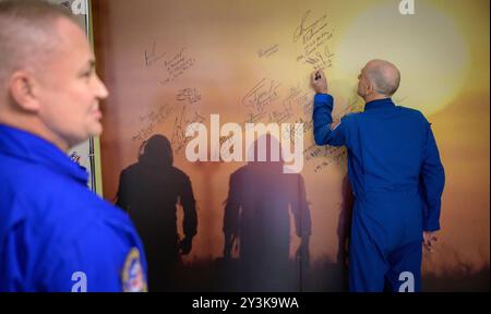Baikonur, Kazakistan. 11 settembre 2024. L'astronauta della NASA Don Pettit, a destra, firma un murale presso il Cosmonaut Hotel prima di partire per vestirsi il giorno del lancio al Cosmodromo di Baikonur, 11 settembre 2024, a Baikonur, Kazakistan. I membri dell'equipaggio della Expedition 72 si stanno dirigendo verso la stazione spaziale Internazionale per una rotazione di routine dell'equipaggio. Crediti: Bill Ingalls/NASA Photo/Alamy Live News Foto Stock