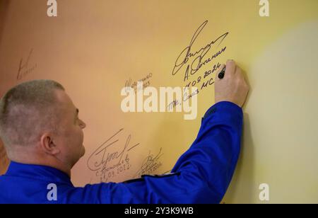 Baikonur, Kazakistan. 11 settembre 2024. Il cosmonauta di Roscosmos Alexey Ovchinin firma un murale presso il Cosmonaut Hotel prima di partire per vestirsi il giorno del lancio presso il Cosmodromo di Baikonur, 11 settembre 2024, a Baikonur, Kazakistan. I membri dell'equipaggio della Expedition 72 si stanno dirigendo verso la stazione spaziale Internazionale per una rotazione di routine dell'equipaggio. Crediti: Bill Ingalls/NASA Photo/Alamy Live News Foto Stock