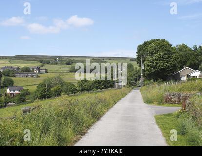 Stretto vicolo di campagna con il villaggio di Wadworth e i campi collinari vicino al ponte hebden a calderdale, nello yorkshire occidentale Foto Stock