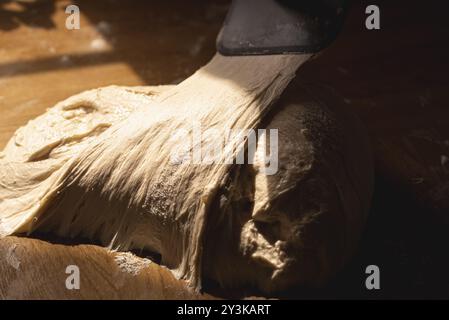 Pane lievito madre su un piano della cucina con luce naturale. Primo piano dell'impasto bianco a base di farina. Impasto fermentato Foto Stock