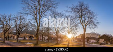 Paesaggio rurale con un villaggio di montagna, sotto un cielo limpido e un sole potente. Foto scattata a Ehrwald, distretto di Reutte, stato del Tirolo, Austria durin Foto Stock