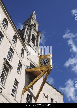 Un primo piano della torre e un orologio d'oro ornato sulla sala civica di leeds, nell'ovest dello yorkshire, contro un cielo nuvoloso illuminato dal sole Foto Stock