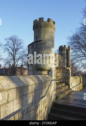 Una vista lungo la passerella pedonale sulle storiche mura medievali della città di york che mostra una delle piccole torri difensive che si trovano a intervalli regolari Foto Stock