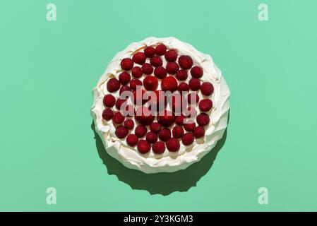 Vista dall'alto con una torta di meringa fatta in casa ripiena di panna montata e ricoperta di fragole e lamponi Foto Stock