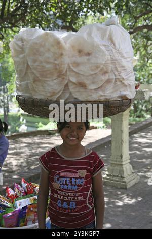 Ragazza Khmer vendita di pane piatto al Wat Phnom in Cambogia Foto Stock