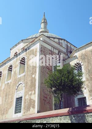 La moschea di solimano nella città vecchia di rodi con cupola e alto minareto contro un cielo blu illuminato dal sole Foto Stock