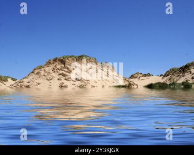 La spiaggia dal mare a formby merseyside con alte dune di sabbia ricoperte di erba grezza e un cielo azzurro estivo illuminato dal sole Foto Stock