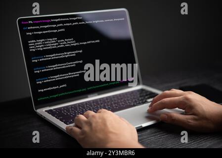 Primo piano della codifica manuale sul computer portatile, che visualizza l'interfaccia di programmazione. Rappresenta lo sviluppo software e la tecnologia. Adatto per QUESTO, conten educativo Foto Stock