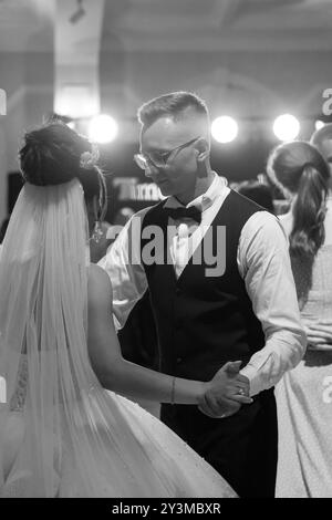 Elegante ballo nuziale bianco e nero che cattura momenti romantici sulla pista da ballo. Foto Stock