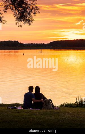 Coppia giovane e romantica che si gode il tramonto sul lago Rothsee vicino a Roth e Norimberga in Baviera in Germania Foto Stock