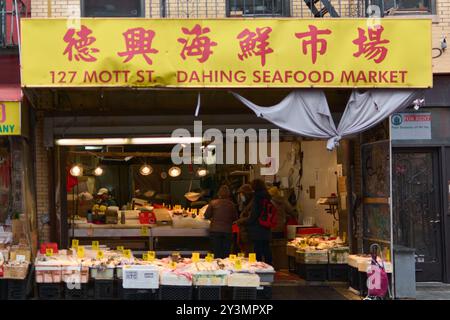 New York, Stati Uniti - 14 settembre 2024: Scena urbana di un affollato mercato di pesce a Chinatown, New York, con prodotti freschi e acquirenti locali. Foto Stock