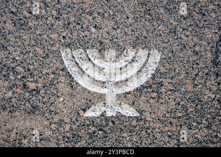 Designazione Menorah con candele accese su pietra granitica. Festeggiamo Hanukkah. Foto Stock