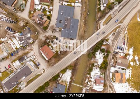 Vista aerea di una piccola città con edifici residenziali e una strada. La neve è visibile sul terreno. Il layout comprende varie strutture, incluso Foto Stock