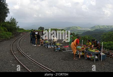 La gente del posto vende frutta locale e prodotti commestibili ai turisti sulla strada verso la stazione della collina di Matheran nel distretto di Raigad, alla periferia di Mumbai. Matheran è una splendida stazione collinare situata alla periferia della città nel quartiere Raigad di Maharashtra. i veicoli a motore sono vietati nella stazione della collina e i turisti possono prendere un treno giocattolo che va proprio all'interno della stazione della collina da dove i turisti possono camminare o noleggiare un risciò trainato a mano o andare a cavallo per visite turistiche all'interno e intorno alla stazione della collina. i mesi monsonici sono favoriti dal turista come l'intera collina Foto Stock