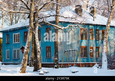 Edificio di appartamenti in legno a due piani nell'entroterra russo in inverno Foto Stock