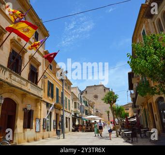 La città mercato di Santanyí guardando lungo Placa Major superava le bancarelle del mercato verso i ristoranti esterni e Sant Andreu de Santanyí in lontananza Foto Stock