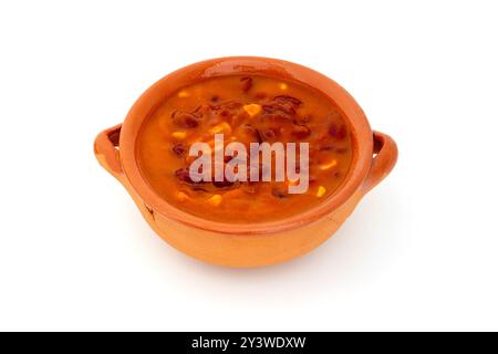 Fagioli cotti in salsa di pomodoro serviti in una tradizionale ciotola di argilla su sfondo bianco Foto Stock