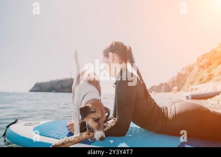 Dog Paddleboard Beach Woman Relaxing - donna e cane si rilassano su un paddleboard in spiaggia. Foto Stock